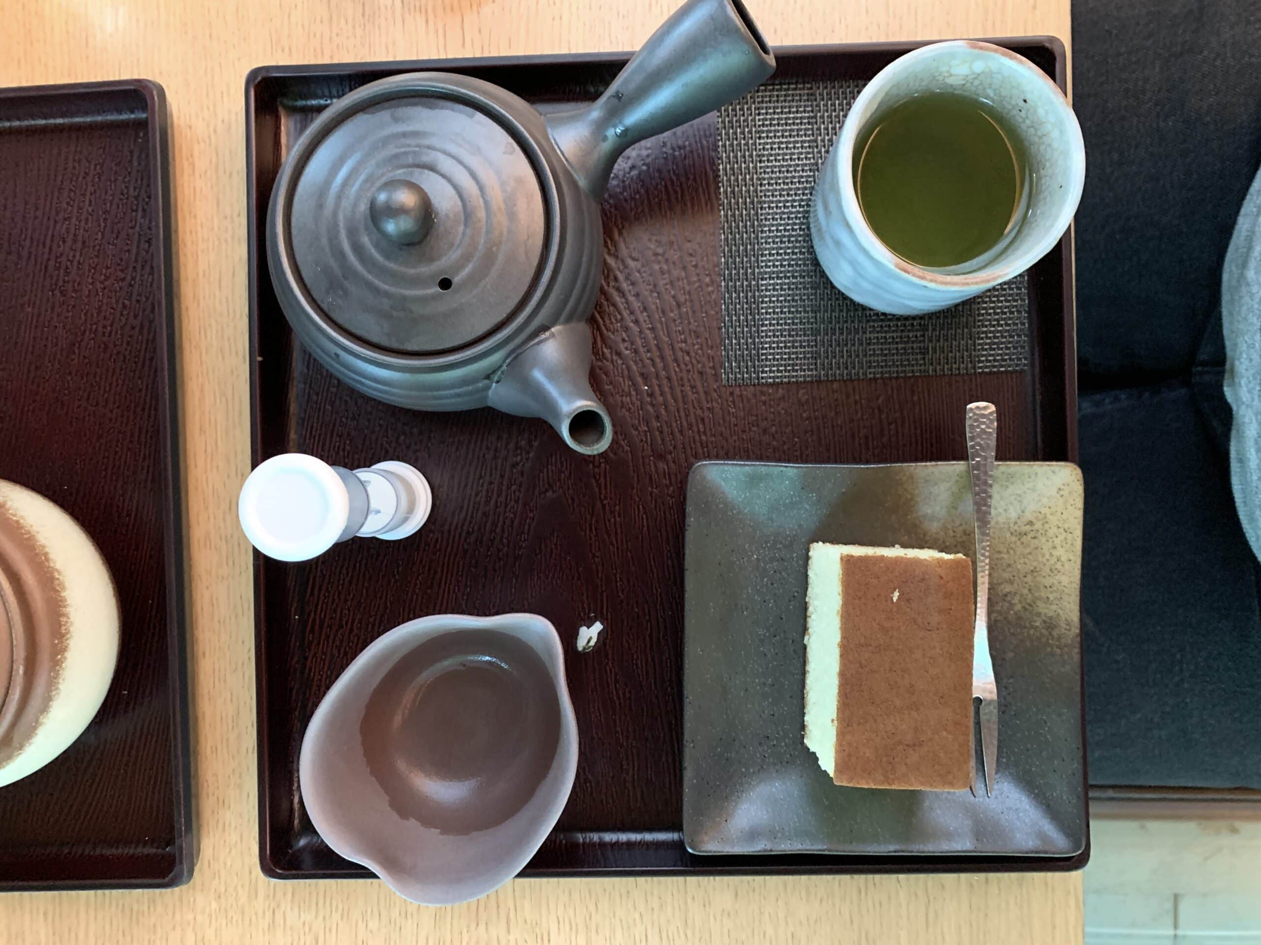 A tray with a kyusu tea kettle of Japanese green tea and a slice of cake at Umami Café in the Portland Japanese Garden